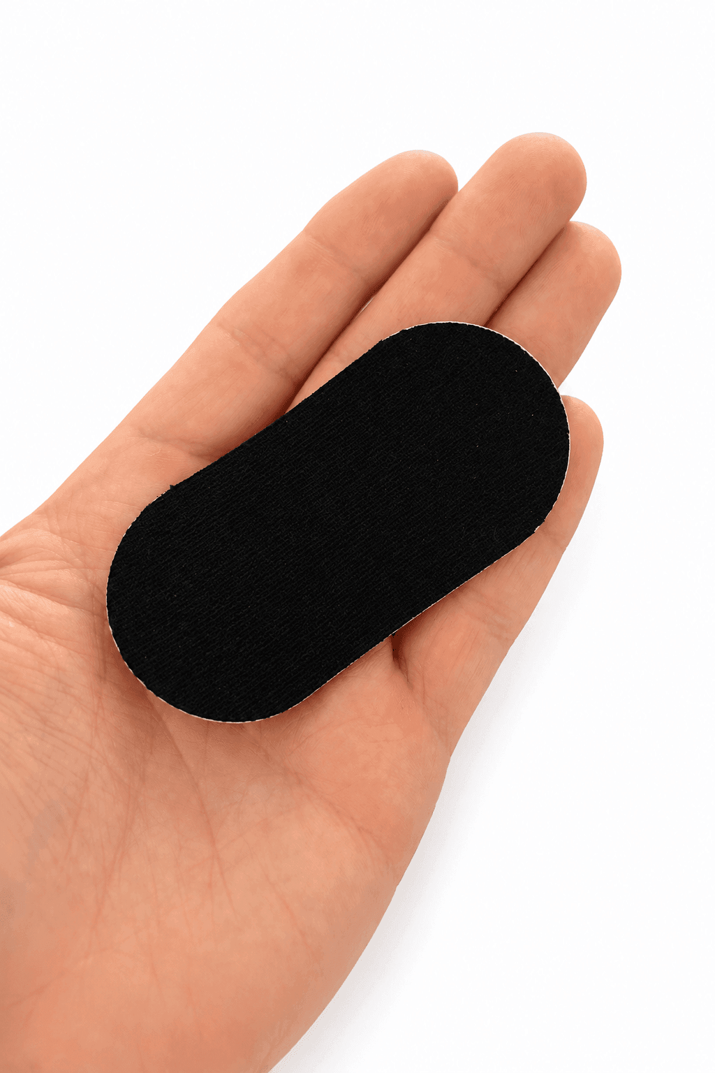 Black BiohackBeast mouth tape strip held in an open palm for sleep, nasal breathing, and mouth taping at night.